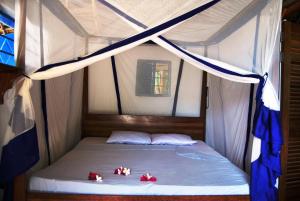 uma cama numa tenda com três ursos em Beach Bungalow 60sqm Fully serviced in Matemwe Zanzibar em Gazija