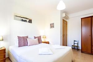 a bedroom with a large white bed in a room at Casa Correia - Charming Holidays House in Vila Nova De Cacela