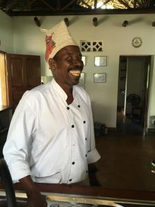 Een man met een koksmuts in een keuken. bij Beach Bungalow 60sqm Fully serviced in Matemwe Zanzibar in Gazija