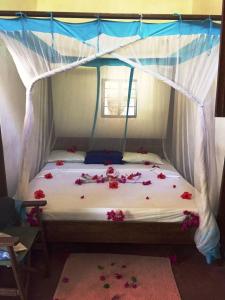 una camera da letto con un letto decorato con fiori di PRIVATE BEACH BUNGALOW ZERO MINUTE to beach Matemwe a Gazija