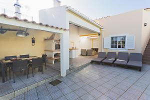 a patio with a table and chairs and a dining room at Casa Correia - Charming Holidays House in Vila Nova De Cacela