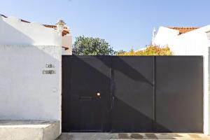 a black gate in front of a white building at Casa Correia - Charming Holidays House in Vila Nova De Cacela