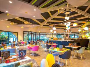 a restaurant with tables and chairs and a cafeteria at ibis Styles Fréjus St Raphael in Fréjus