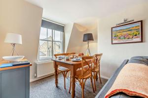 a room with a table and chairs and a bed at The Nest, Winchcombe in Winchcombe