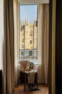 a chair with a bag sitting in front of a window at Palazzo Cordusio, a Gran Melia Hotel in Milan