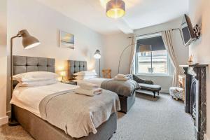 a bedroom with two beds and a tv in it at The Nest, Winchcombe in Winchcombe