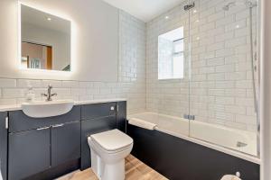 a bathroom with a sink and a toilet and a tub at The Nest, Winchcombe in Winchcombe
