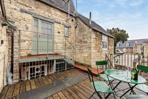 a patio with a table and chairs on a deck at The Nest, Winchcombe in Winchcombe