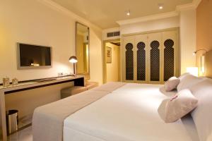 1 dormitorio con 1 cama blanca grande y escritorio en Vincci Albayzin, en Granada