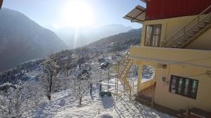 a stairway to a building on a snowy mountain at Hotel Rocks and pine Auli in Joshīmath