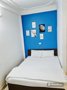 a bed in a room with a blue wall at Bluebell Hotel in Hanoi