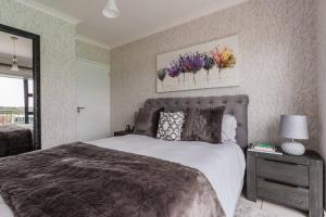 a bedroom with a large bed and flowers on the wall at Pax's Luxury Romantic Penthouse on the Lagoon in Pretoria +6 photos