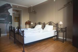 a bed with white sheets and pillows in a room at Hotell Vaxblekaregården in Eksjö