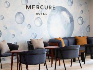 a group of chairs and tables in a room at Mercure Sydney Blacktown in Blacktown