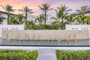 un panneau devant un complexe avec des palmiers dans l'établissement Hilton Vacation Club Cabo Azul Los Cabos, à San José del Cabo