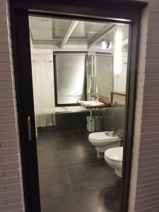 a bathroom with two toilets and a sink at Casa bajo el acueducto con plaza de garaje in Segovia