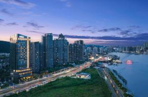 une ville de nuit avec une rivière et des bâtiments dans l'établissement Hilton Zhuhai, à Zhuhai