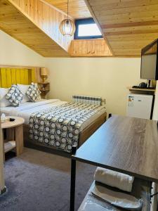 a bedroom with two beds and a table in it at Alex Hotel in Yerevan