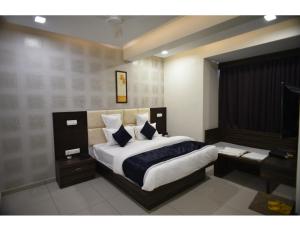 um quarto com uma cama king-size e uma secretária em Hotel Royal Residency, Vadodara em Vadodara