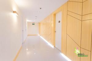 - un couloir avec un sol blanc et des murs en bois dans l'établissement Etsu Hotel, à Tacloban