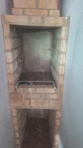 einen gemauerten Kamin in der Ecke eines Zimmers in der Unterkunft Casa a 5 Minutos Da Praia in Armacao dos Buzios