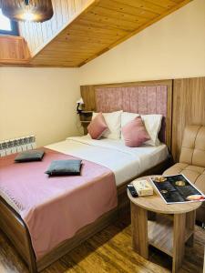 Alex Hotel في يريفان: غرفة نوم بسريرين وطاولة واريكة