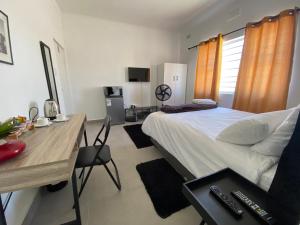 a bedroom with a bed and a desk and a table at No 1 Guest house in Cape Town