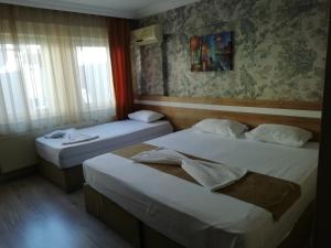 チャナッカレにあるGrand Ece Hotelのベッド2台と窓が備わるホテルルームです。