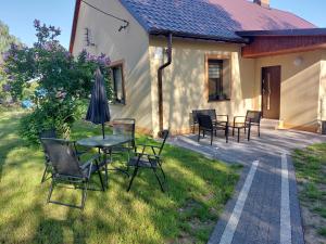 un patio con sillas, una mesa y una sombrilla en Lawendowy zakątek en Graboszyce