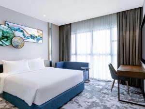 a hotel room with a bed and a desk at Mercure Kuala Lumpur Trion in Kuala Lumpur +18 photos