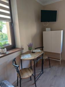 Zimmer mit einem Tisch, 2 Stühlen und einem TV in der Unterkunft Lawendowy zakątek in Graboszyce
