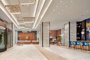 a lobby of a hotel with blue chairs and tables at Hilton Garden Inn Wuhan Hankou in Wuhan