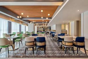 a dining room with tables and chairs at Hilton Garden Inn Wuhan Hankou in Wuhan