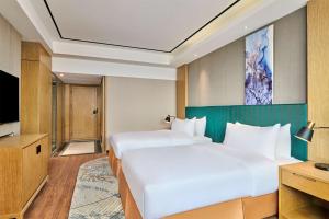 Postel nebo postele na pokoji v ubytování Hilton Garden Inn Wuhan Hankou