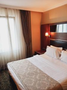 イスタンブールにあるDream Hill Business Deluxe Hotel Asiaの大きなベッドと窓が備わるホテルルームです。