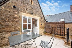 a patio with a table and chairs in front of a brick building at The Haven in Chipping Norton