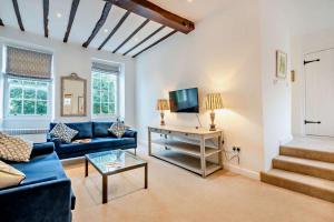 ein Wohnzimmer mit einem blauen Sofa und einem Tisch in der Unterkunft The Haven in Chipping Norton