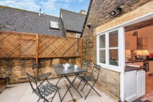 a table and chairs on a patio with a kitchen at The Haven in Chipping Norton