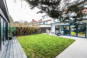 a backyard with a lawn and a house at Luxury 3BR Flat, Parking & Garden, NW London in London