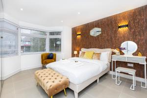 a bedroom with a large bed and a mirror at Luxury 3BR Flat, Parking & Garden, NW London in London