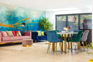 a living room with a table and chairs at Luxury 3BR Flat, Parking & Garden, NW London in London