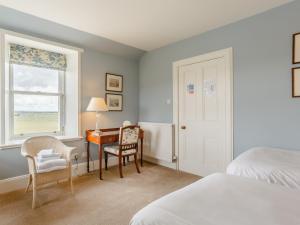 een slaapkamer met een bureau, een bed en een raam bij 3 Bed in John O Groats CA337 in Mey