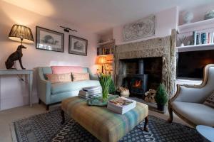 a living room with a couch and a fireplace at Charming Coates Cottage in Baslow