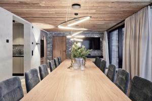 a conference room with a long wooden table and chairs at Chalet White Pearl by MYALPS in Sölden