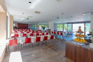 Rimske Terme Resort - Vila Sisi في ريمسكي توبليتسي: قاعة احتفالات مع طاولات وكراسي في غرفة