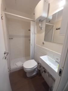 a white bathroom with a toilet and a sink at Milazzo23 in Rome
