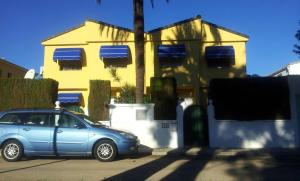 a blue car parked in front of a yellow house at GRAN ADOSADO EN ZONA TRANQUILA CON PISCINA PRIVADA solo familias in Gandía