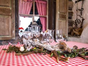 a table with wine glasses and a flower arrangement on it at Guest house pension Neumayer in Fieberbrunn