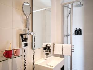 a bathroom with a sink and a mirror at Max Brown Hotel Museum Square, part of Sircle Collection in Amsterdam