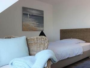 um quarto com uma cama e uma cadeira de vime em Holiday home Crimea em Pommerby
